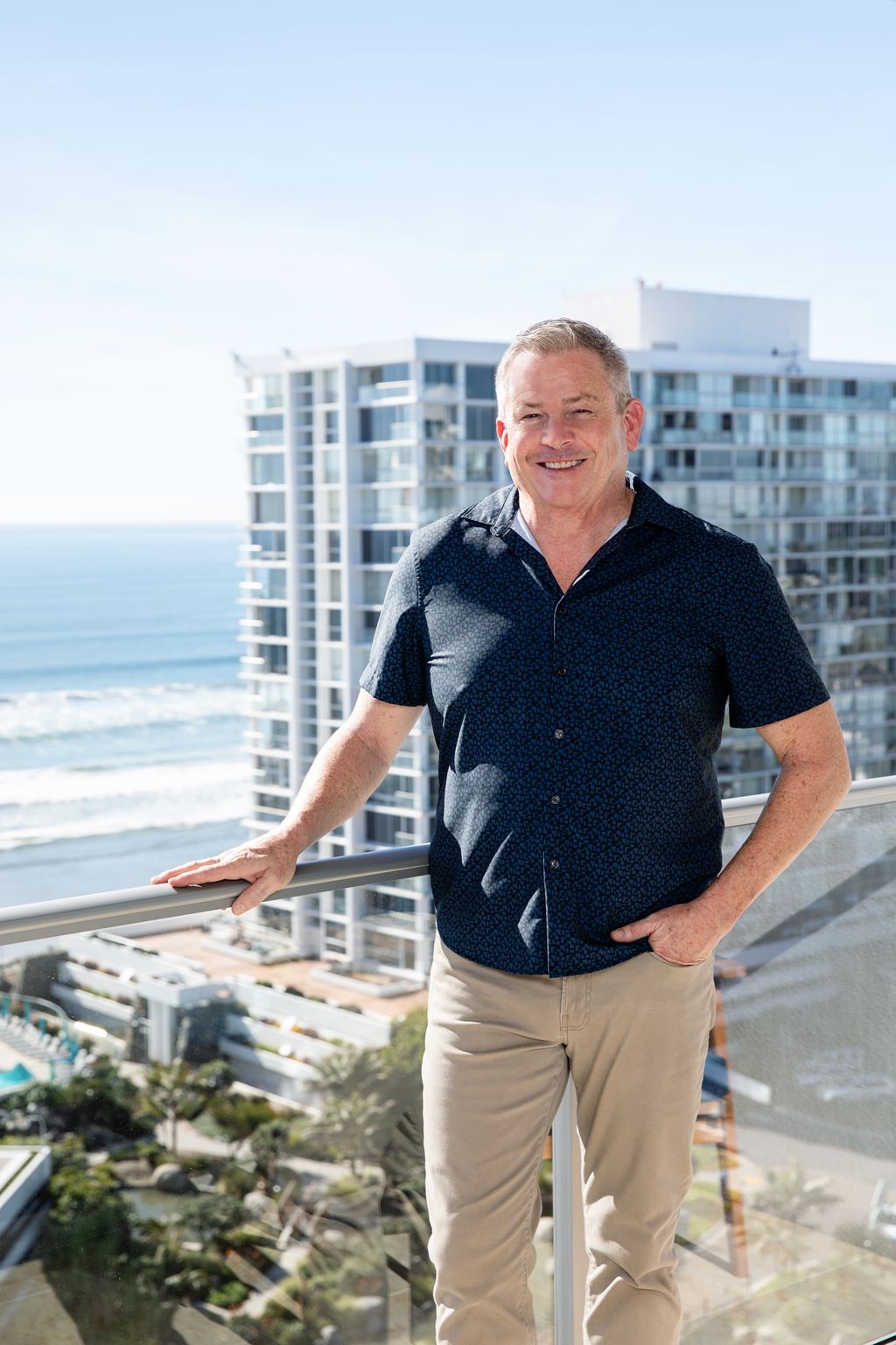 Tom Tilford, real estate broker associate, standing on a Coronado balcony overlooking the ocean